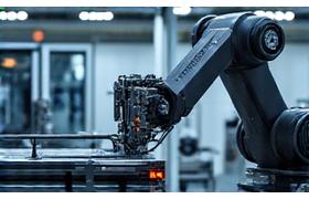 Detailansicht einer modernen Sondermaschine mit Roboterarm in einer Produktionshalle